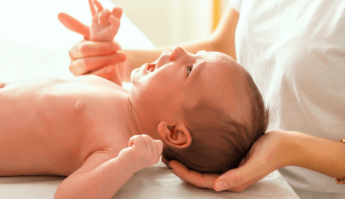 Bebé sujetado por fisioterapeuta