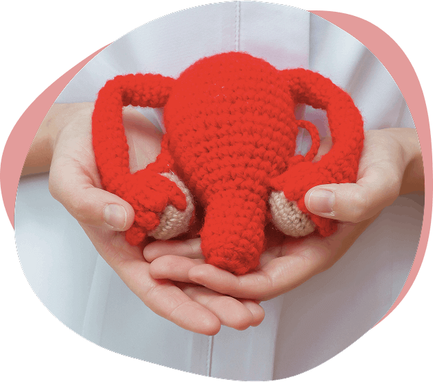Utero de peluche de color rojo sujetado por unas manos