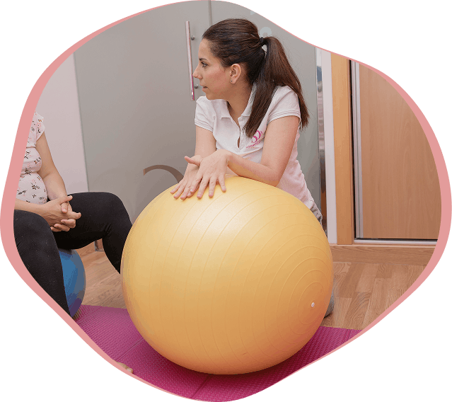 Susana apoyada en una pelota terapéutica amarilla